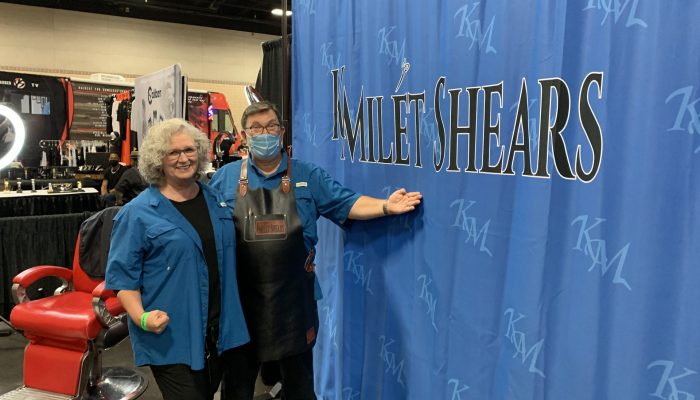 Owners in front of their company banner